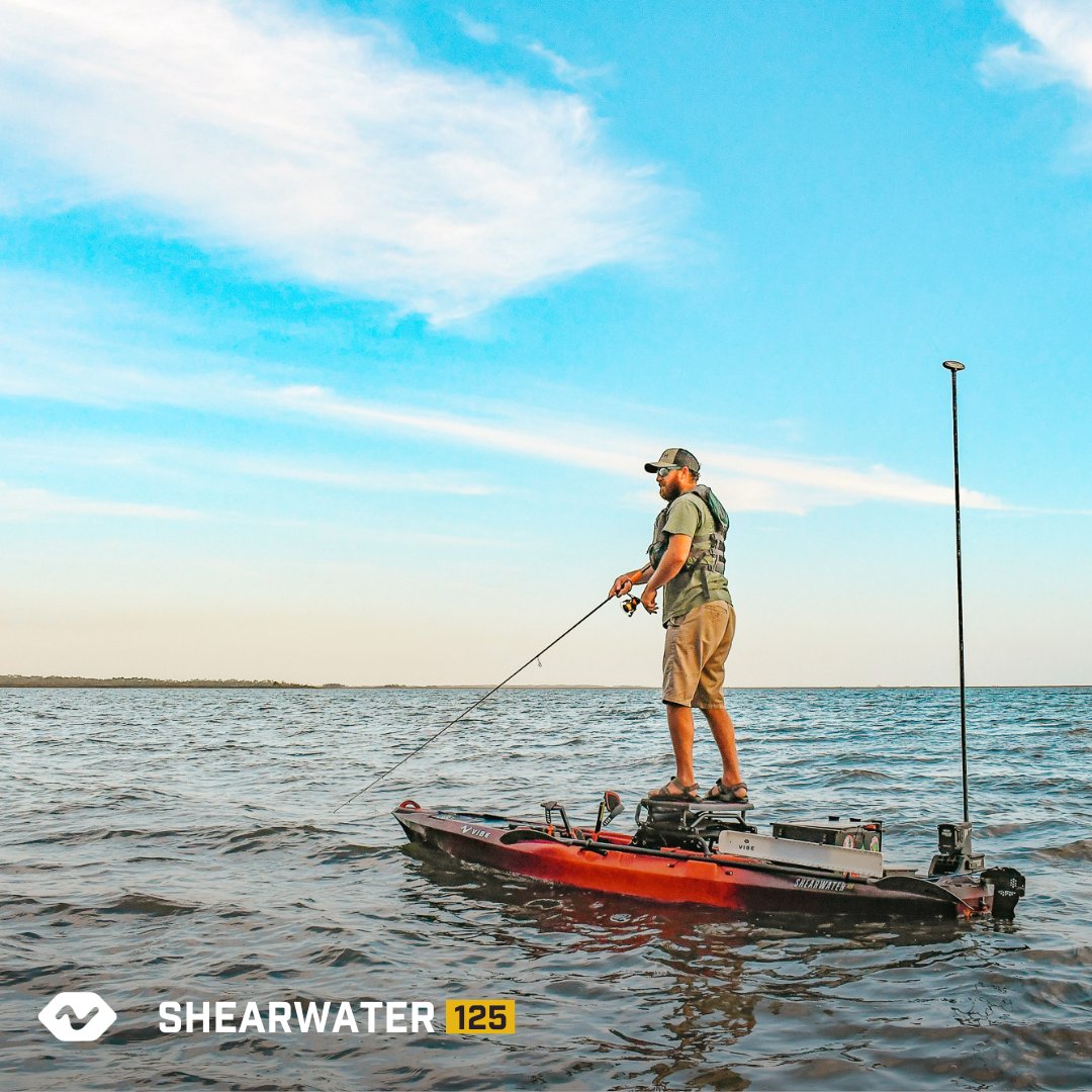 Angler standing fishing on Tsunami Red Shearwater 125 at sunset
